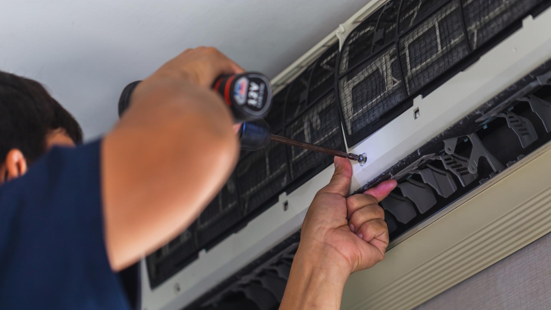 technician close up with drill repairing air conditioner fort lauderdale fl